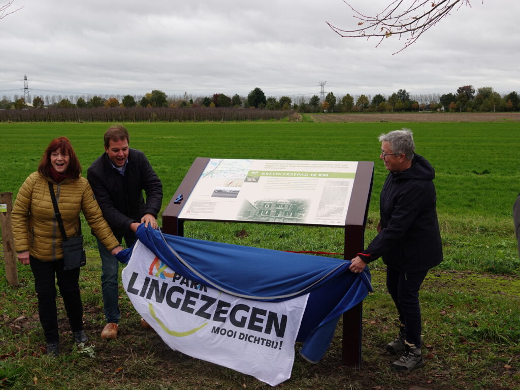 Wethouder Nick Hubers (gemeente Lingewaard) opent samen met vrijwilligers Marijke en Jose het nieuwe Klompenpad 'Breedlersepad'. 